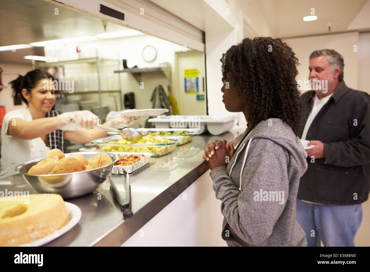 Servez de la nourriture dans la cuisine pour sans-abri Banque D'Images Servez de la nourriture dans la cuisine pour sans-abri Banque D'Images