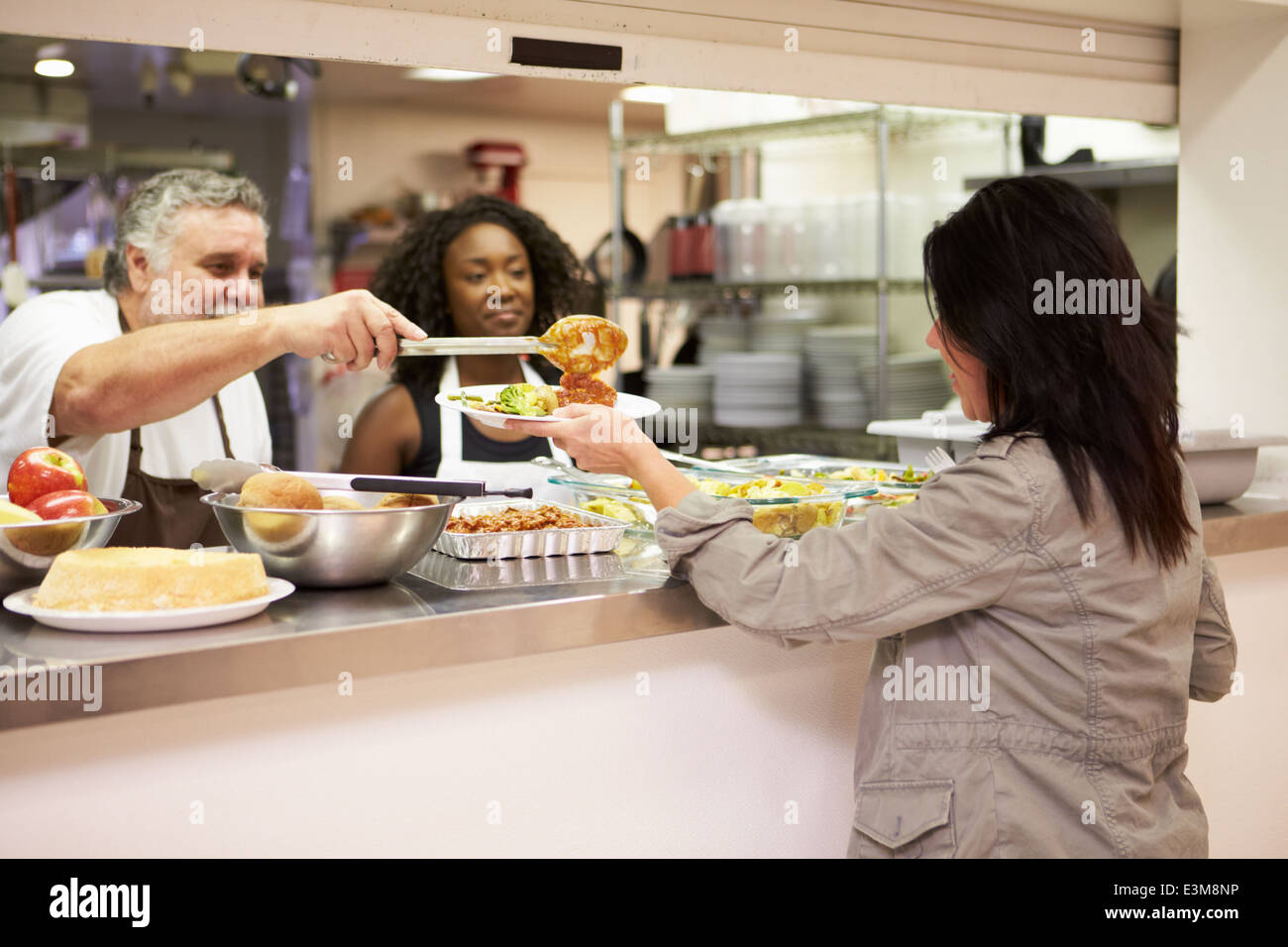 Servez de la nourriture dans la cuisine pour sans-abri Banque D'Images Servez de la nourriture dans la cuisine pour sans-abri Banque D'Images