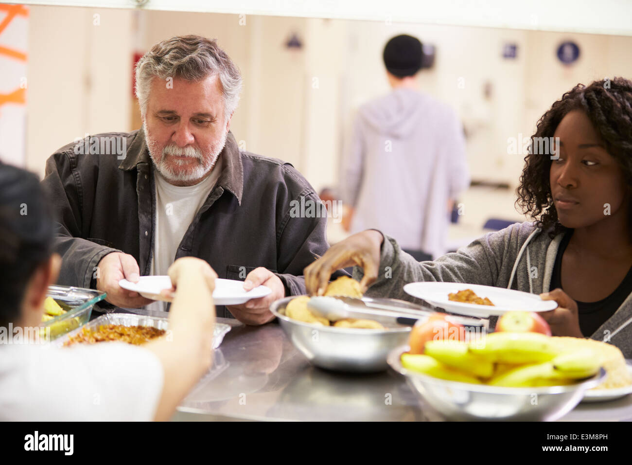Servez de la nourriture dans la cuisine pour sans-abri Banque D'Images Servez de la nourriture dans la cuisine pour sans-abri Banque D'Images