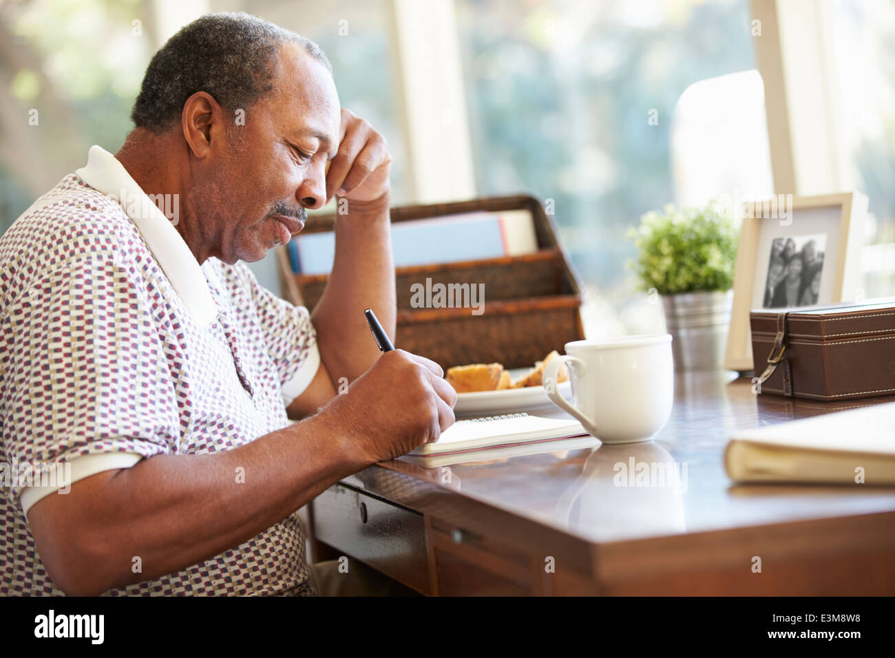 Man écrit mémoires En Book Sitting At Desk Banque D'Images