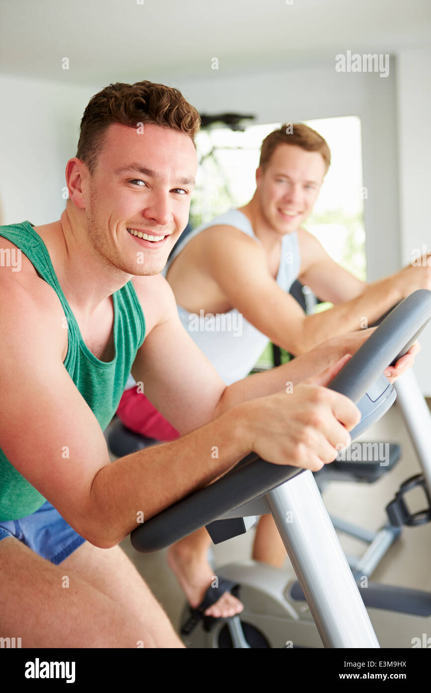 Deux jeunes hommes en formation sur l'ensemble des machines de Sport cyclisme Banque D'Images