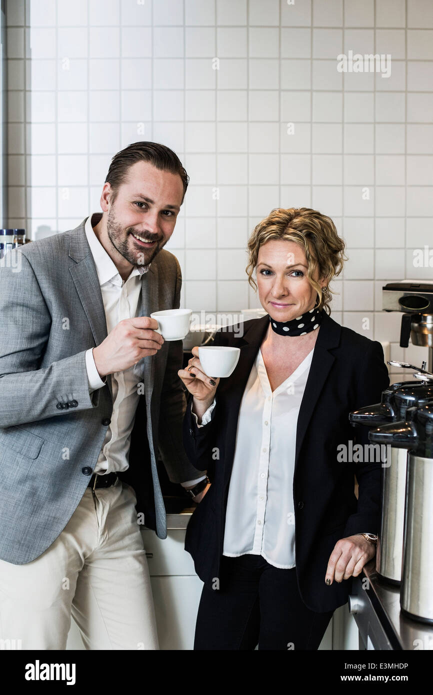 Portrait of smiling business people having coffee in kitchen Banque D'Images