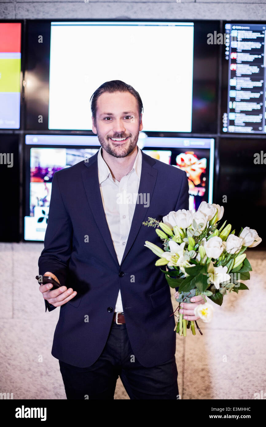 Portrait d'affaires réussi holding bouquet in office Banque D'Images