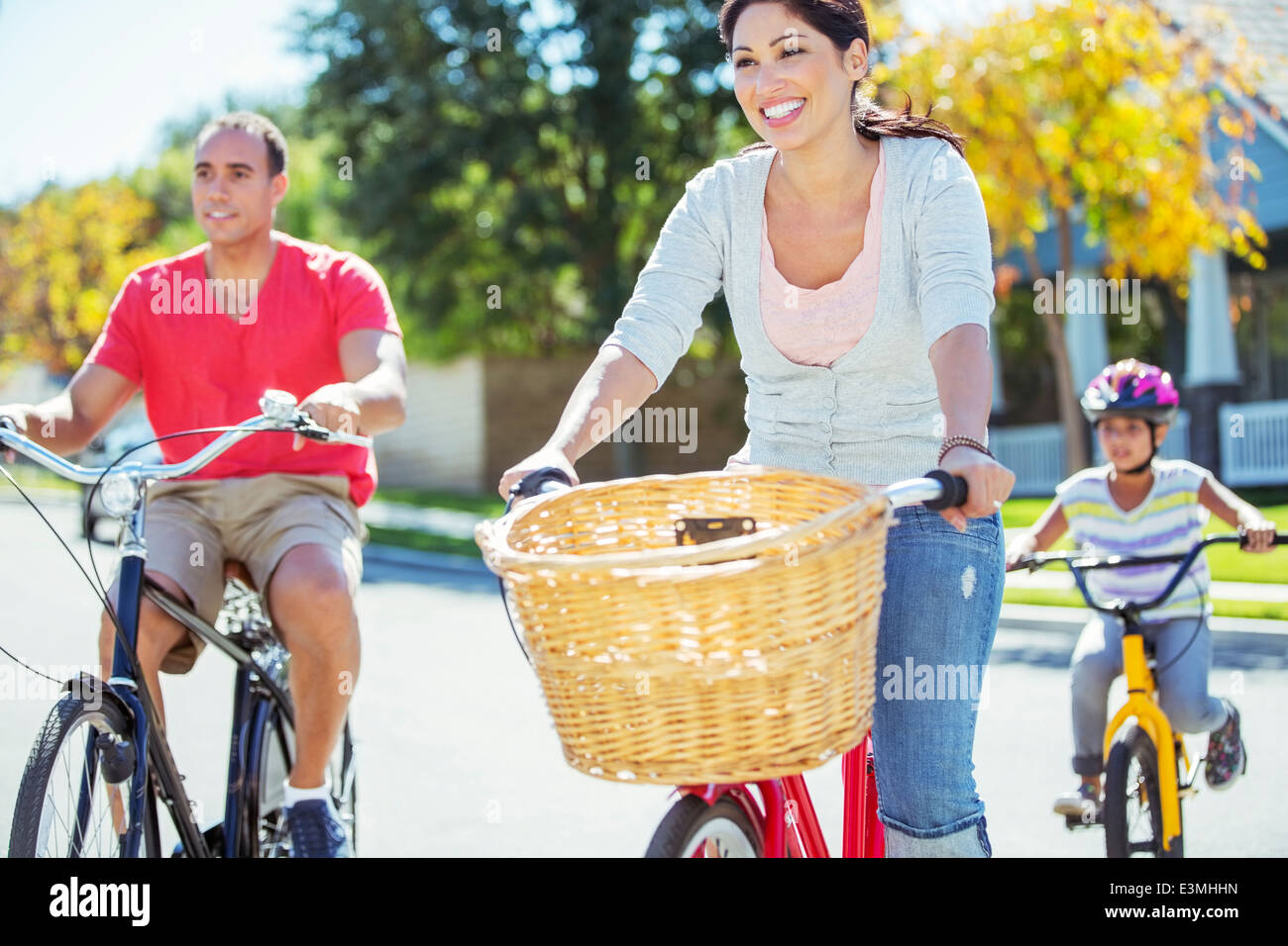 Happy Family riding bikes sur sunny street Banque D'Images