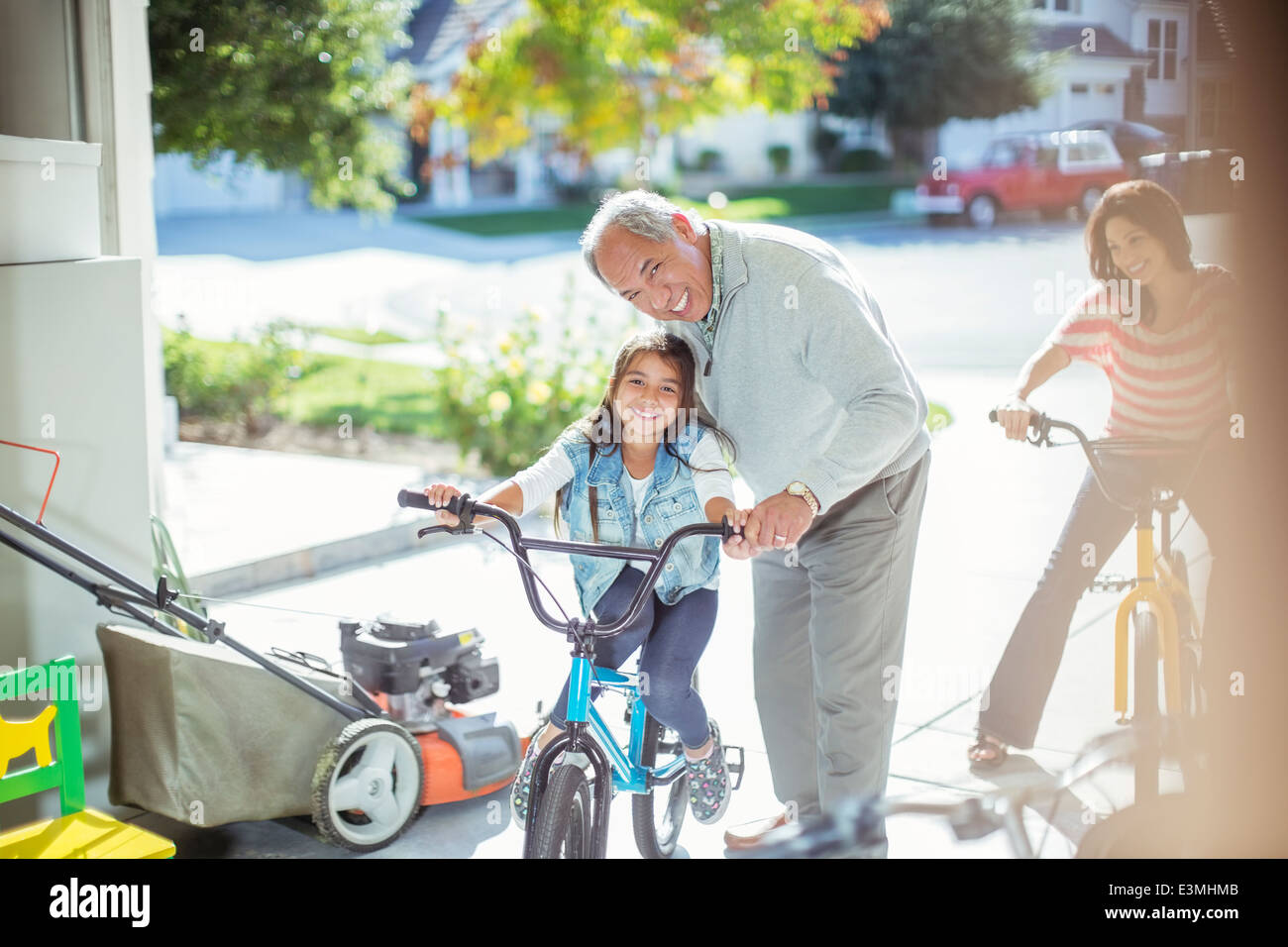 Grand-père et sa petite-fille en vélo dans garage Banque D'Images