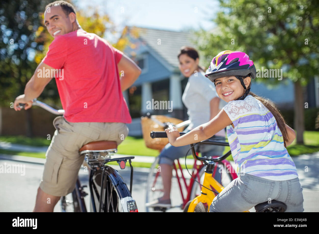 Portrait of family riding bikes on street Banque D'Images