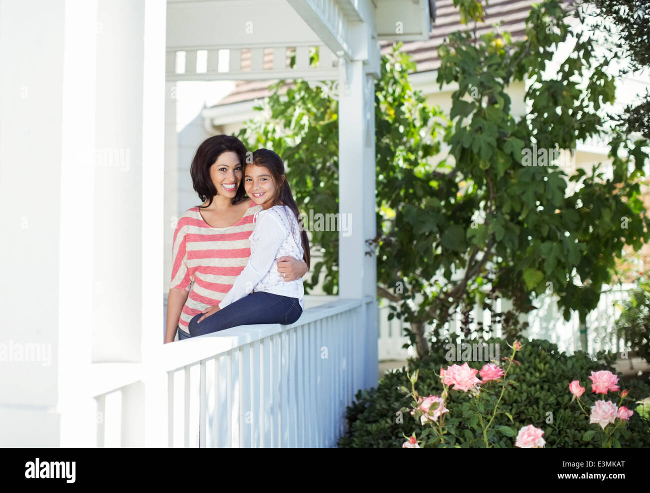 Portrait of smiling mother and daughter on porch Banque D'Images