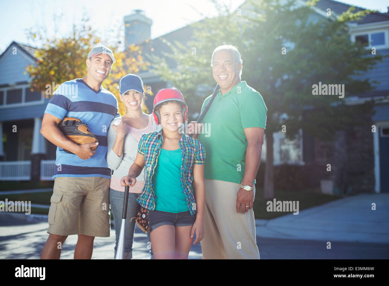 Portrait of smiling multi-generation family with baseball bat dans Street Banque D'Images