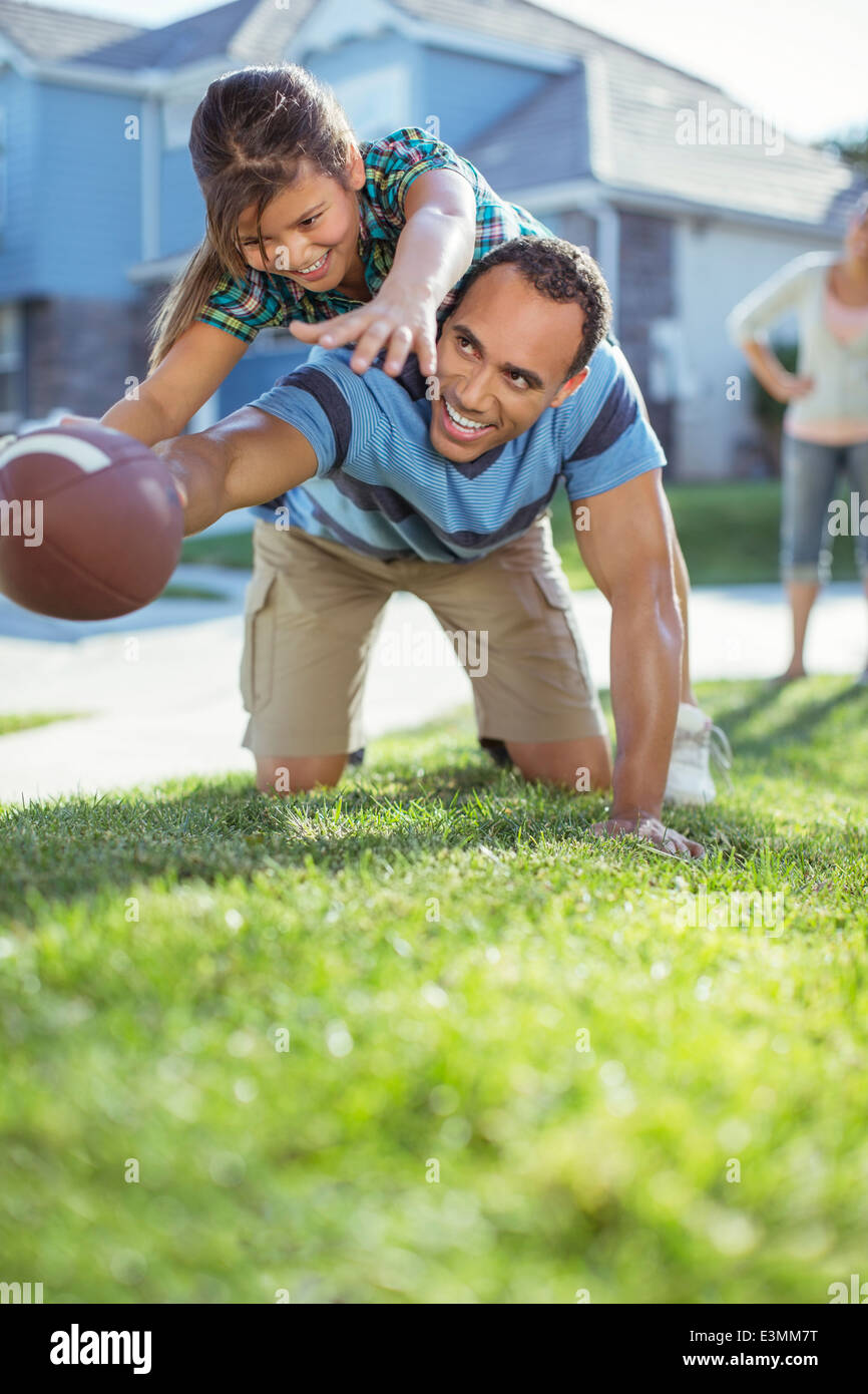 Père et fille à jouer au football dans l'herbe Banque D'Images