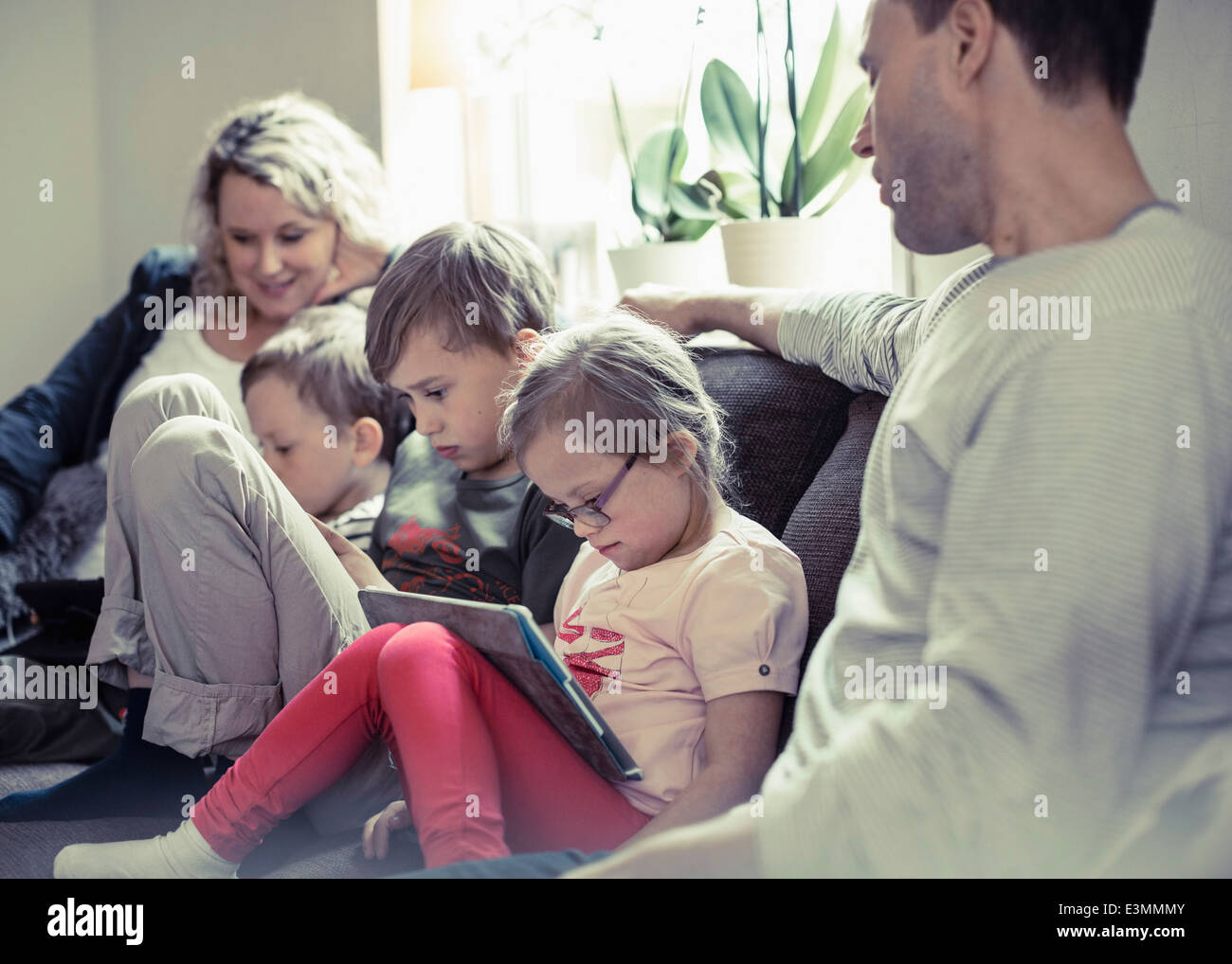 Famille de cinq sitting on sofa at home Banque D'Images