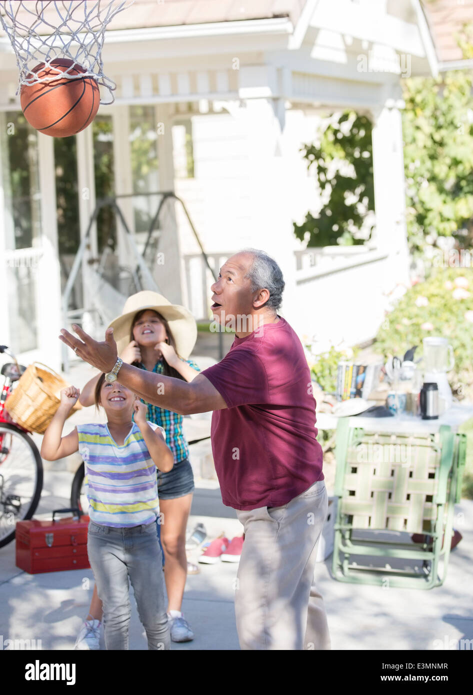 Grand-père et petites-filles jouant au basket-ball Banque D'Images