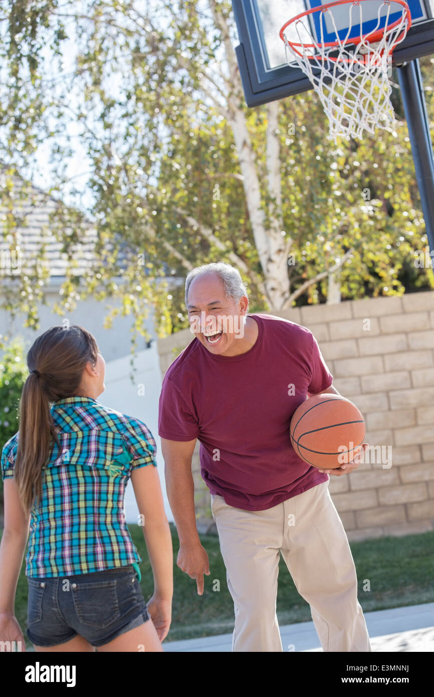 Grand-père et sa petite-fille jouant au basket-ball en entrée Banque D'Images