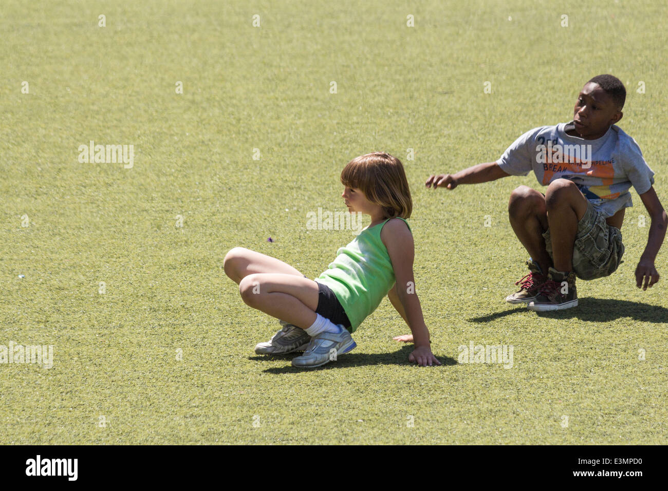 Jeune Pré-ado fille et garçon jouant sur l'herbe à Harbourfront à Toronto (Ontario) Banque D'Images