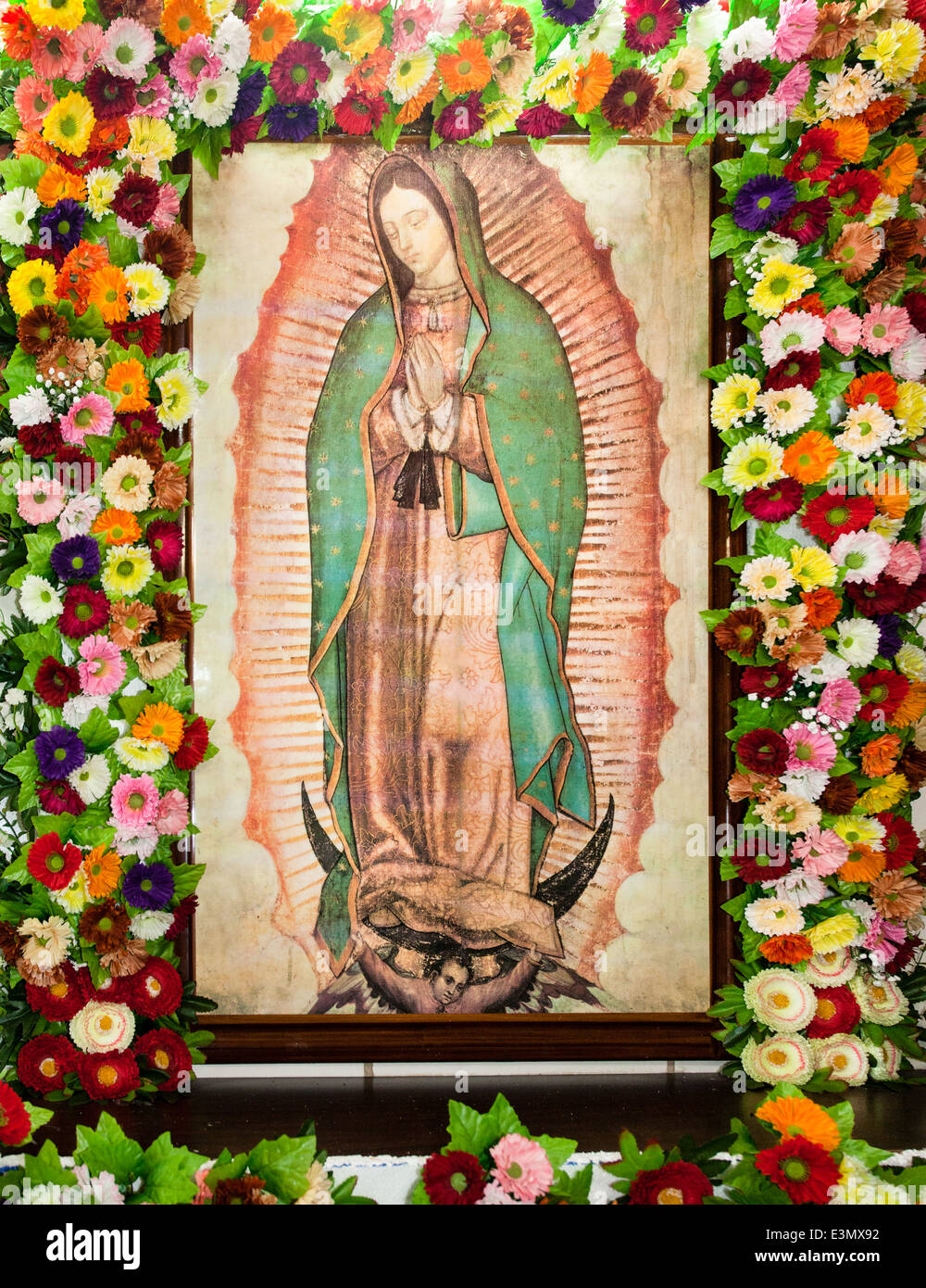 La Vierge de Guadalupe encadrée par des fleurs dans le marché de Villahermosa, Tabasco au Mexique. Banque D'Images