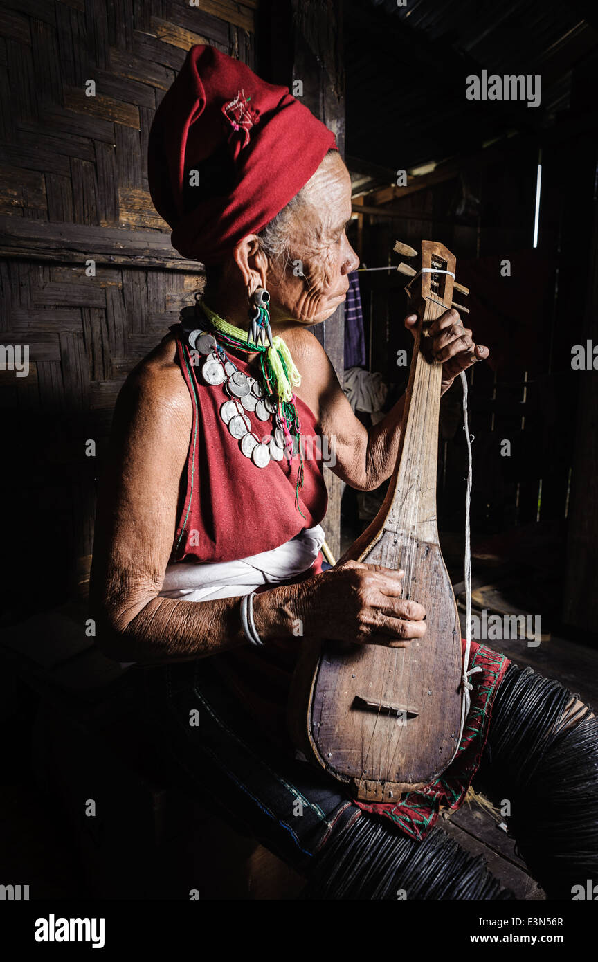 Kayah vieille femme jouant de la guitare, une sorte de zone de Loikaw, Myanmar, en Asie Banque D'Images