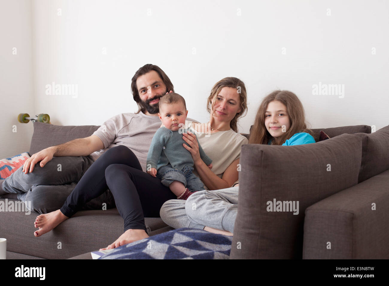 Portrait de famille avec deux enfants sitting on sofa in living room Banque D'Images