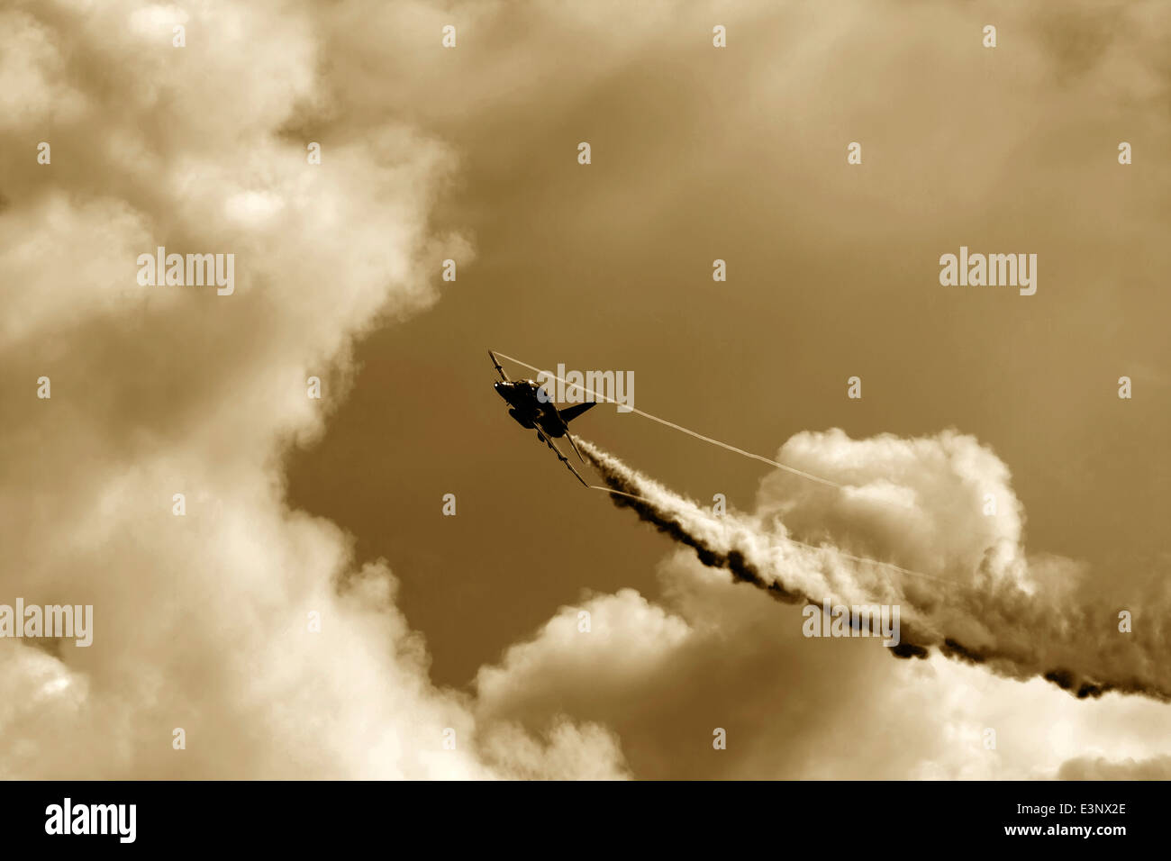 Vol en avion de chasse à ciel nuageux avec ligne d'échappement d'épaisseur derrière elle. Banque D'Images