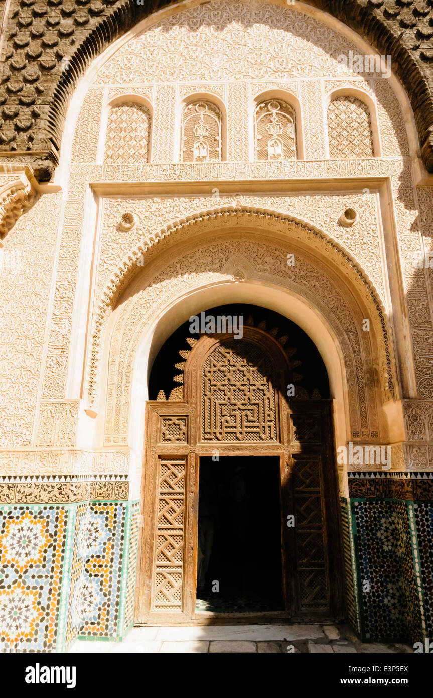 Les carreaux de céramique à motifs complexes sur les murs autour d'une porte en bois au Musée de Marrakech, Maroc Banque D'Images