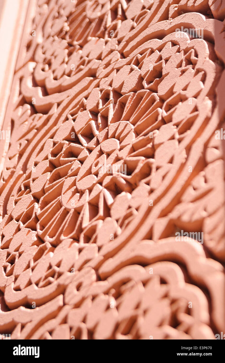Pierre sculptée ornée autour de la porte d'un bâtiment à Marrakech, Maroc Banque D'Images