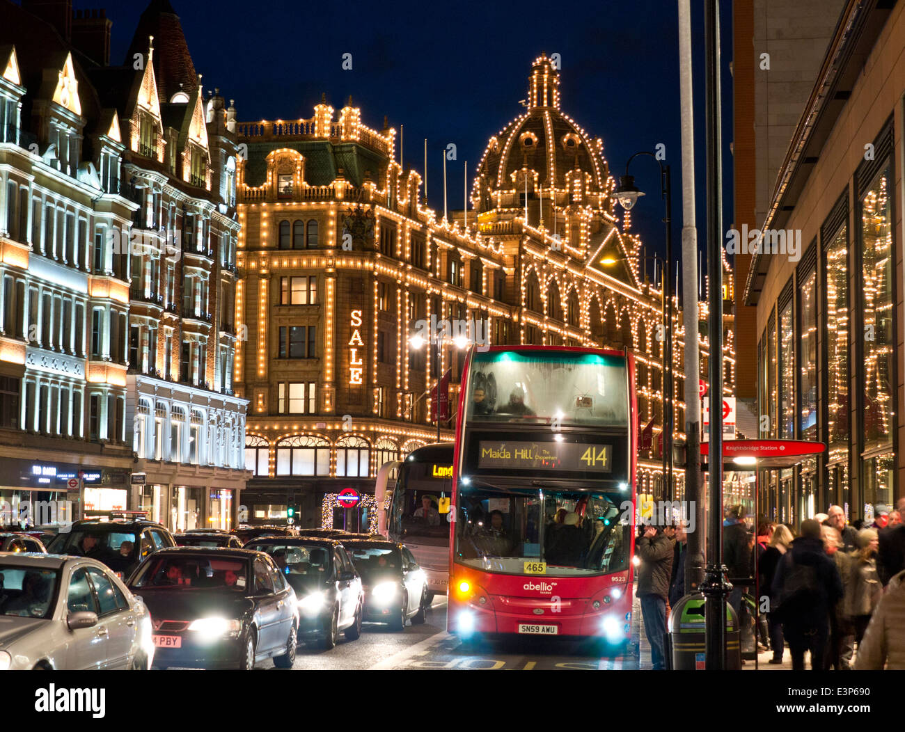 Harrods au crépuscule avec 'sale' sign red bus shoppers et le trafic important Knightsbridge Londres SW1 Banque D'Images