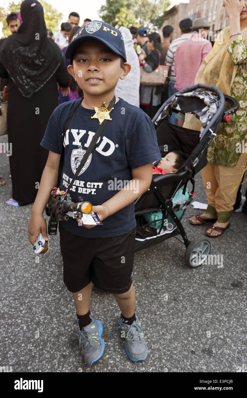 Garçon porte des t-shirt NYPD et porte pistolet jouet à foire de rue dans 'Little Bangladesh' dans la section de Kensington Brooklyn, 2014. Banque D'Images