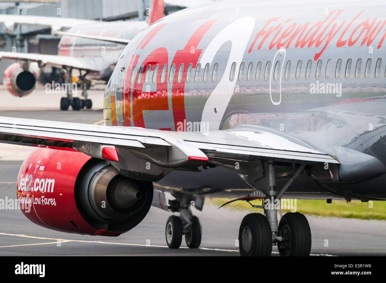 Un gros plan d'une aile de Boeing 737 Jet 2.Com et moteur avec un jet2 Boeing 757 à l'arrière-plan à l'aéroport de Manchester Banque D'Images