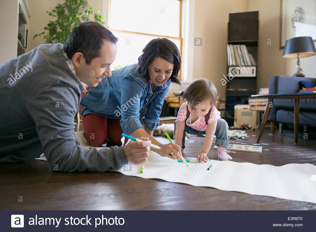 Jeune famille dimensions dans la salle de séjour Banque D'Images