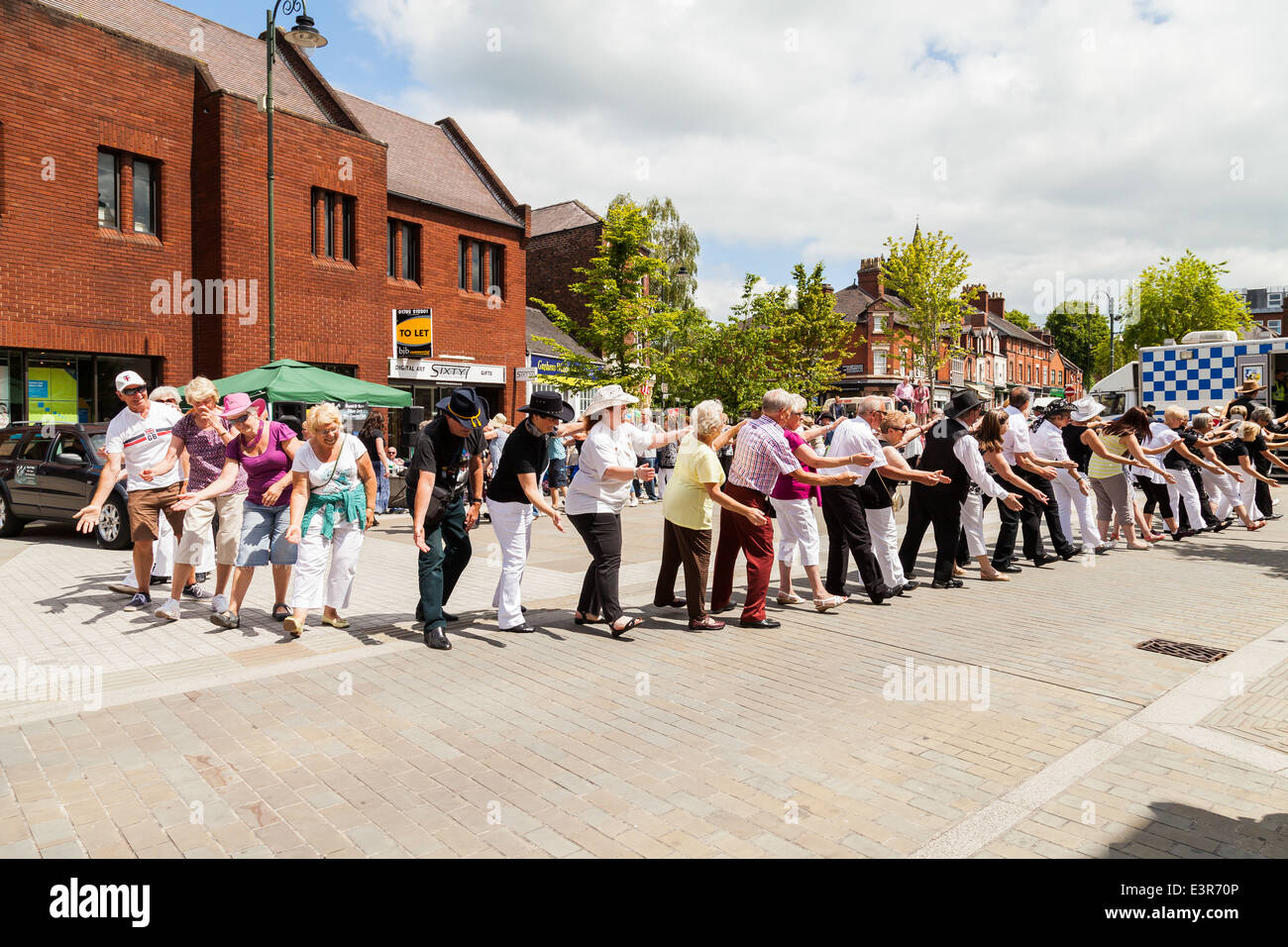 Les gens de danse en ligne à Leek centre-ville. Poireau, Staffordshire, Angleterre, Royaume-Uni. Banque D'Images