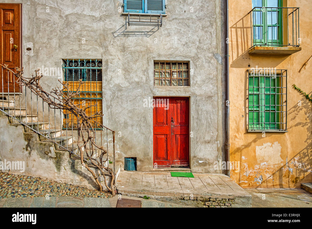 Façade de maison typiquement italien avec des fenêtres et des portes de la ville de Saluzzo en Piémont, Italie du Nord. Banque D'Images