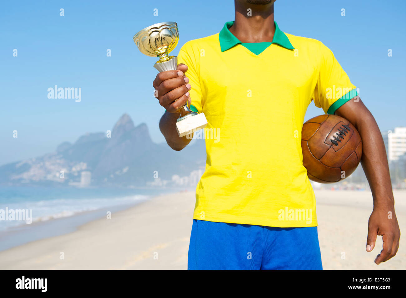 Champion de football brésilien holding trophy et vintage d'un ballon de football de plage d'Ipanema Rio de Janeiro Brésil Banque D'Images