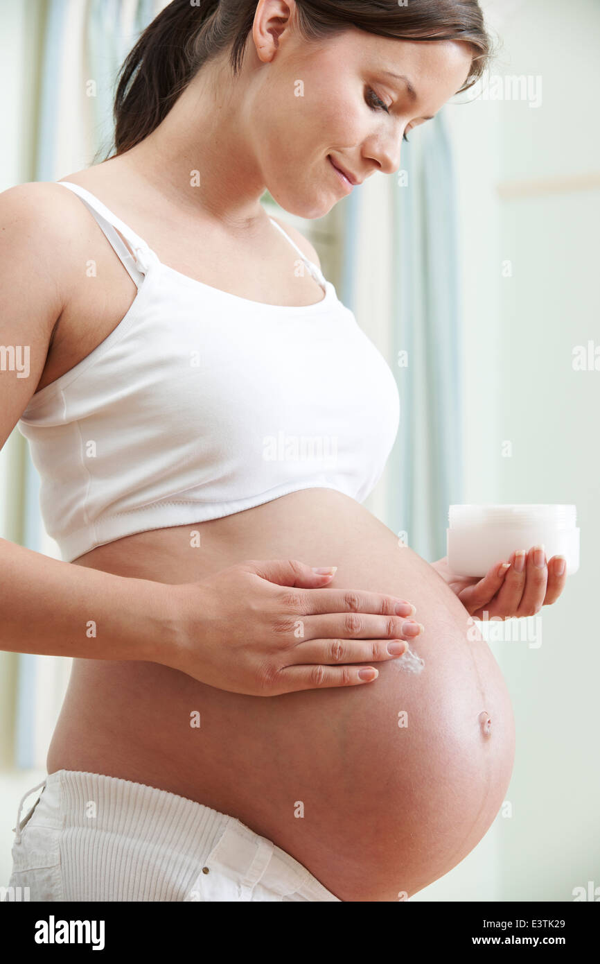 Femme enceinte ventre hydratant Banque D'Images