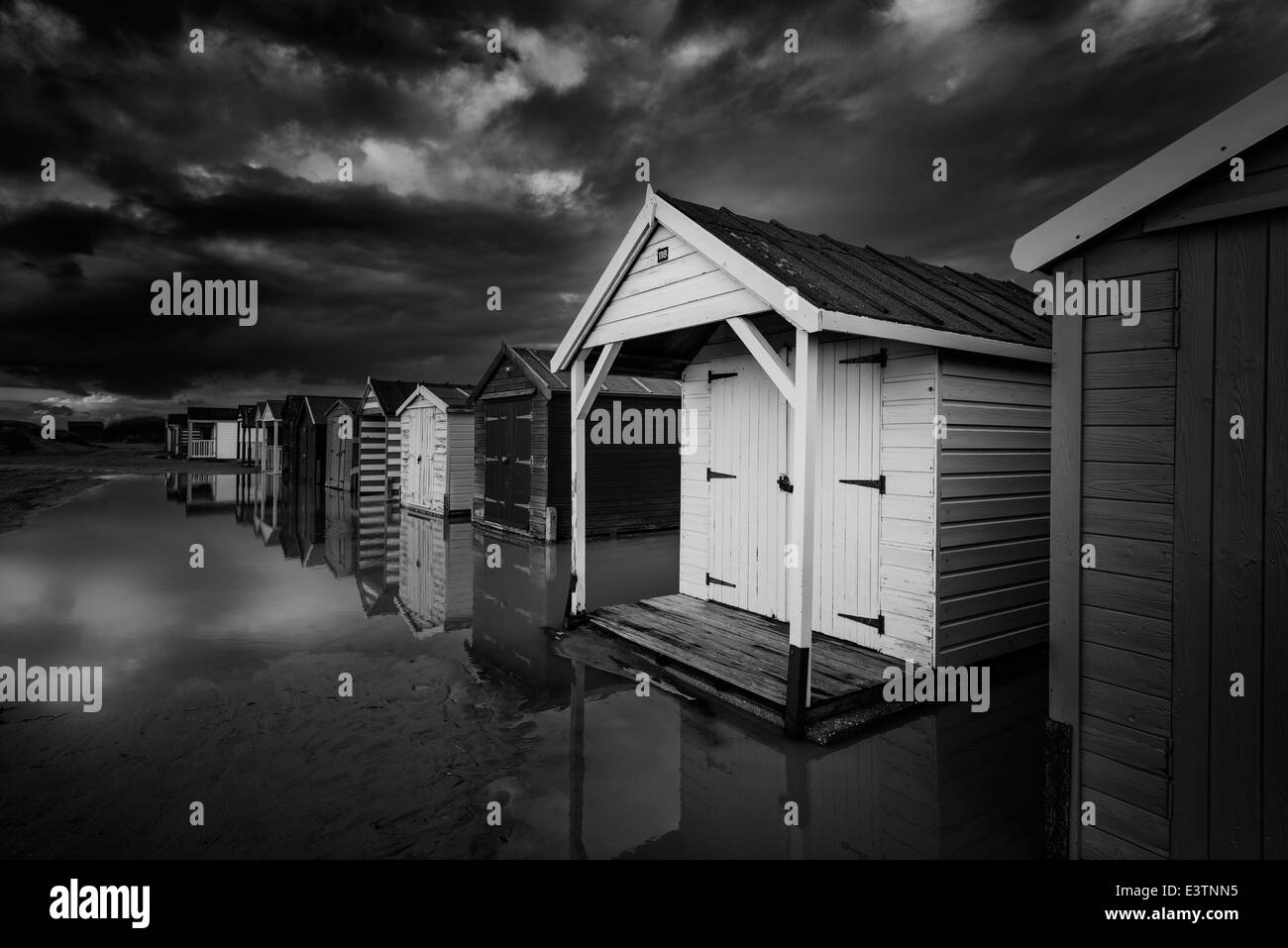 Un rendu noir et blanc de cabanes de plage sur la plage de sable de West Wittering, West Sussex, UK Banque D'Images