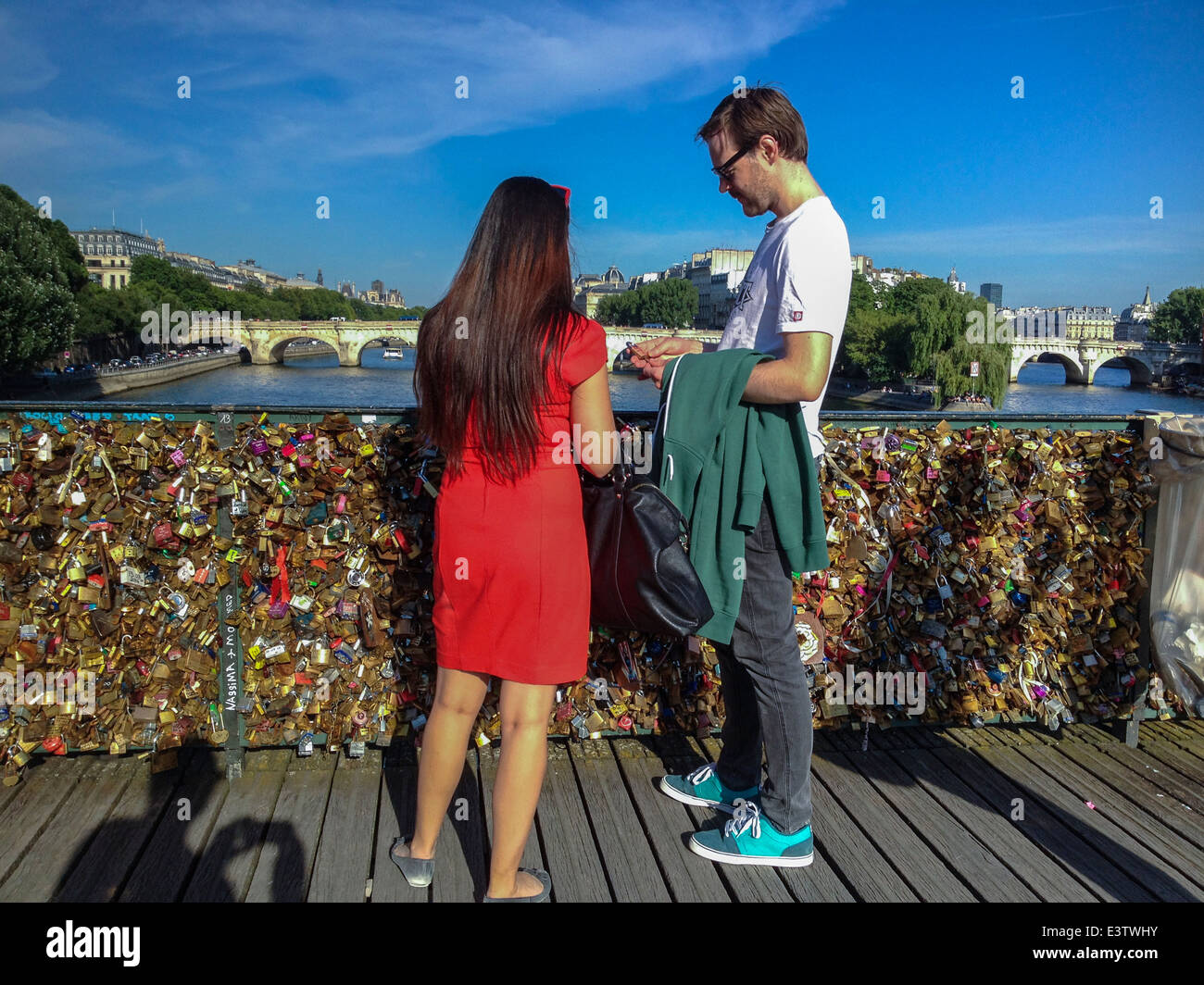 Paris, France, couple touristique sur le pont de la Seine, Pont des Arts avec écluses d'amour, femme debout en robe rouge, vacances européennes d'escapade d'un week-end Banque D'Images