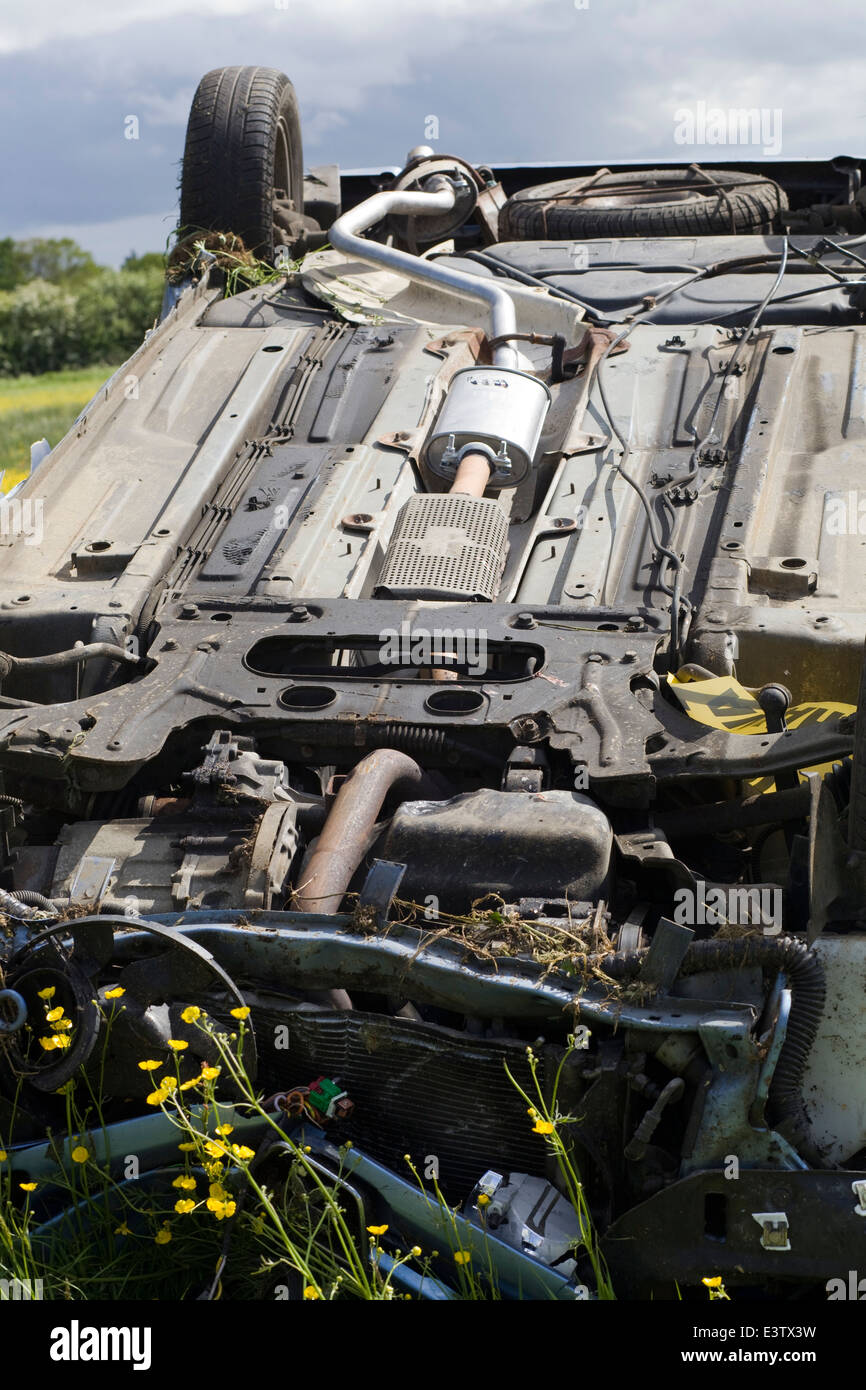 Voiture roulé dans une prairie de renoncule après l'accident de la route Banque D'Images