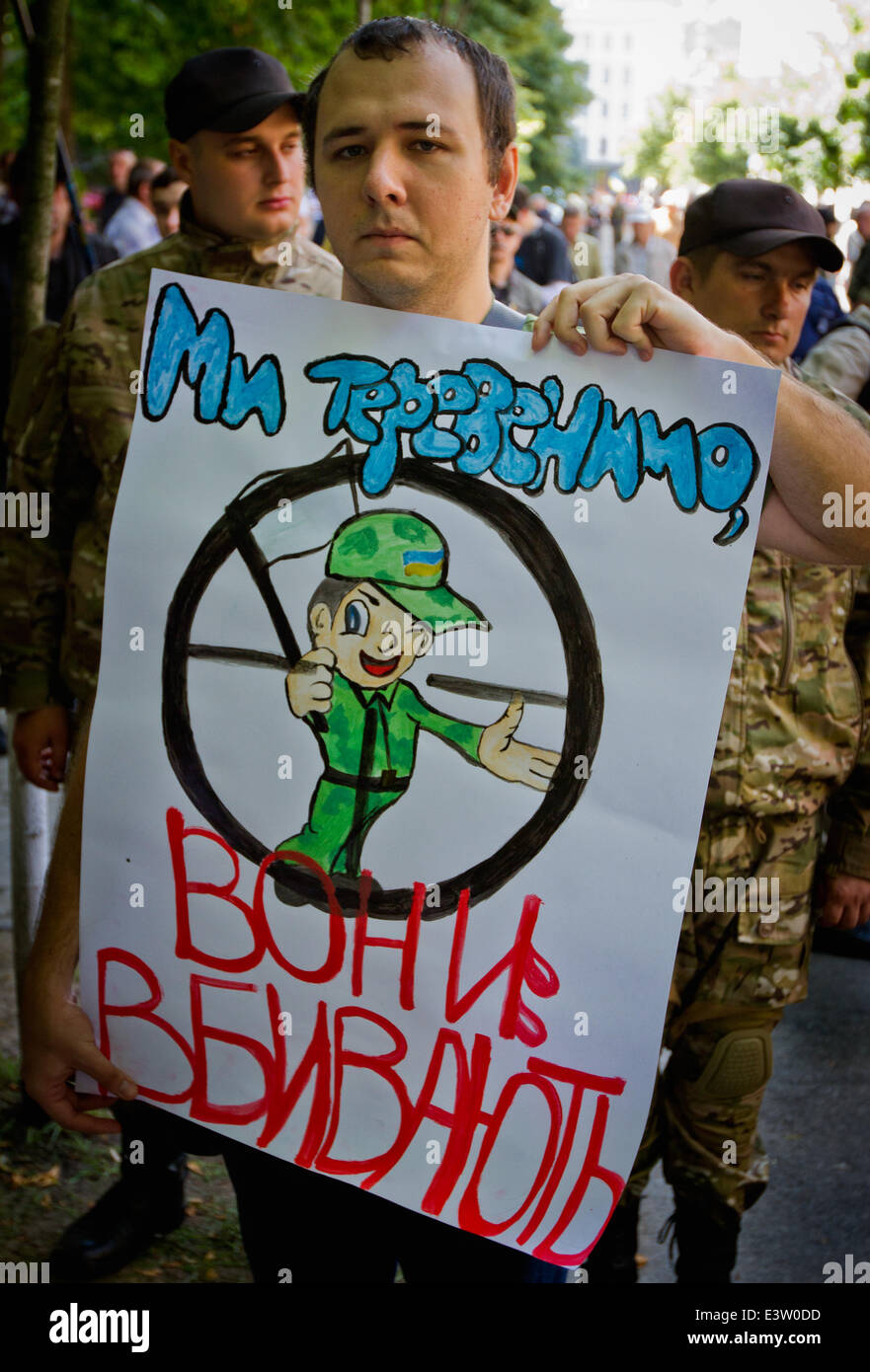 Kiev, Ukraine. 29 Juin, 2014. Un homme est titulaire d'un signe qui dit "Nous avons battu l'air - ils tuent !" comme lui et d'autres personnes participent à un rassemblement de militants de Maidan à la place de l'Indépendance à Kiev, appelant le président ukrainien à abandonner le cessez-le-feu avec les séparatistes armés pro-Russie dans l'Est du pays. © Sergii Kharchenko/Pacific Press/Alamy Live News Banque D'Images