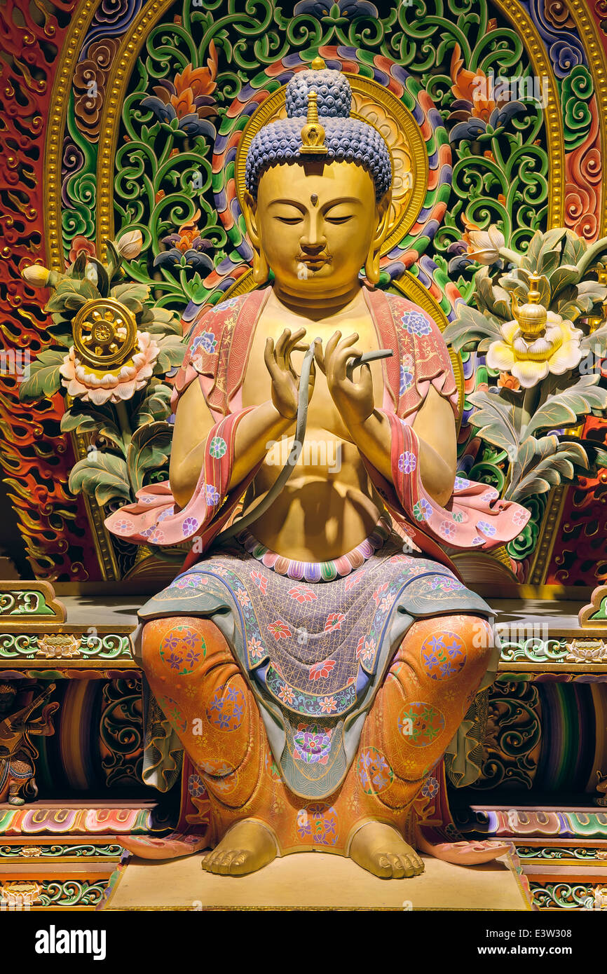 Bois sculpté Statue de Bouddha assis colorés avec des arrière-plan coloré Banque D'Images