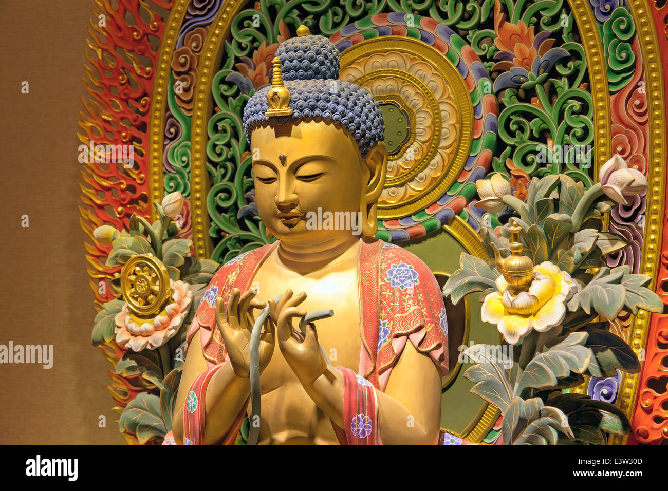 Bois sculpté Statue de Bouddha assis colorés avec des gros plan arrière-plan coloré Banque D'Images