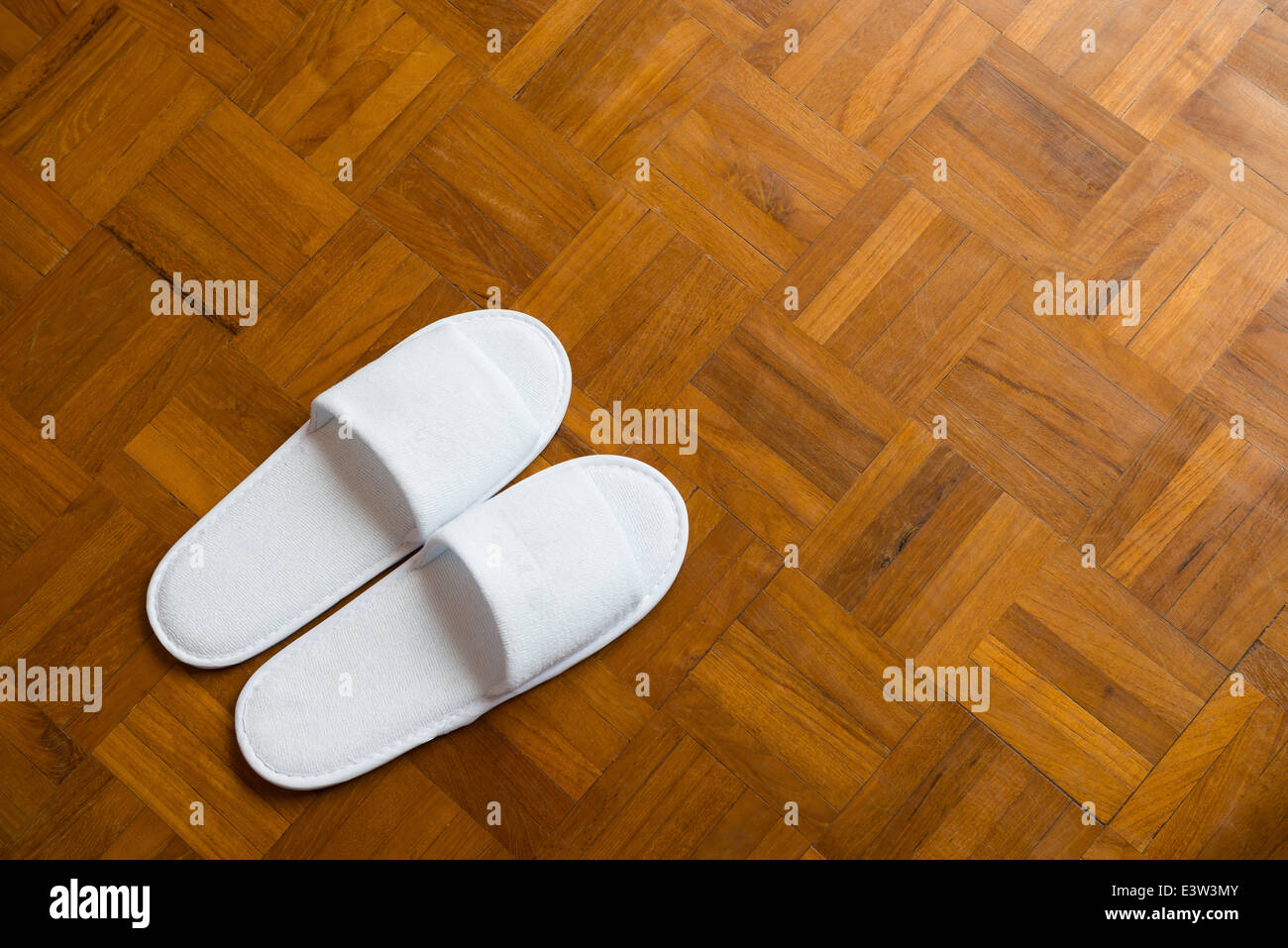 Paire de chaussons blanc sur un sol en bois Banque D'Images