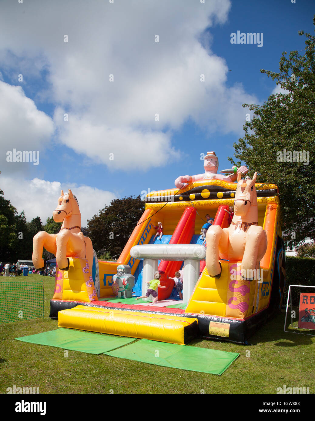 Un château gonflable d'une charrette et cheval à Denbigh carnival sur une journée ensoleillée avec ciel bleu Banque D'Images