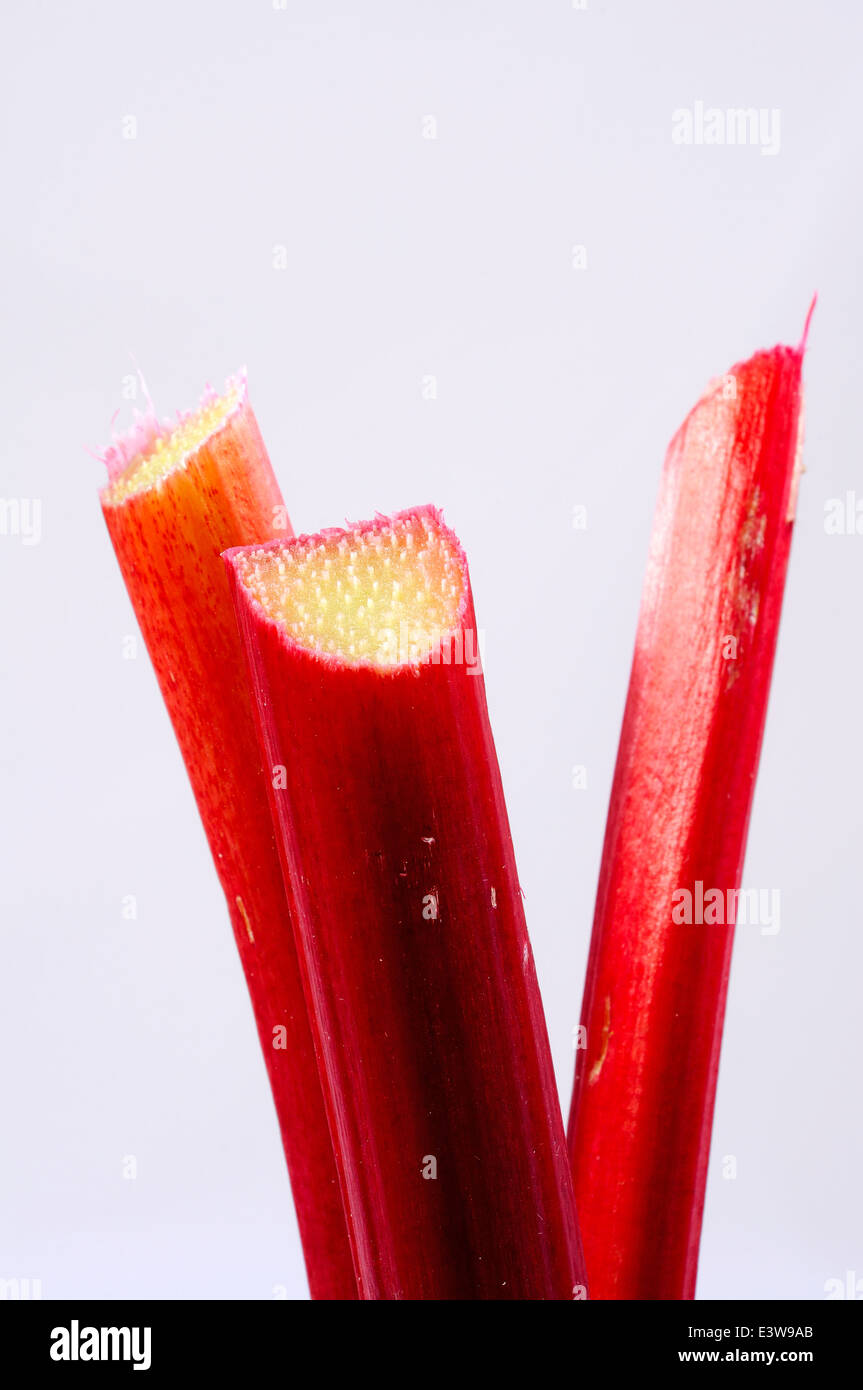 Trois bâtons de rhubarbe contre un arrière-plan. Banque D'Images