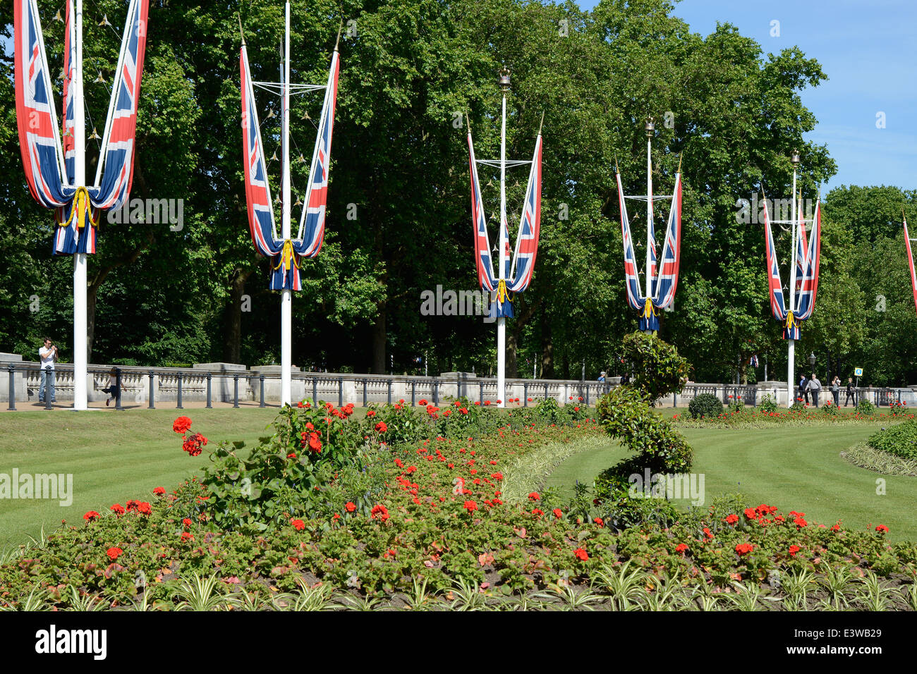 Drapeaux de l'Union britannique autour du Queens Gardens à l'extérieur de Buckingham Palace. Westminster. Londres. L'Angleterre. Avec les touristes. Banque D'Images