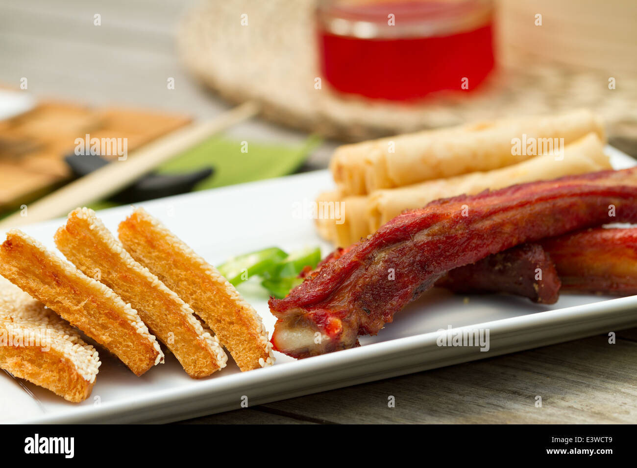 Hors d chinois sur un plateau à l'extérieur, y compris les rouleaux de printemps, côtes et crevettes sésame sur toast Banque D'Images