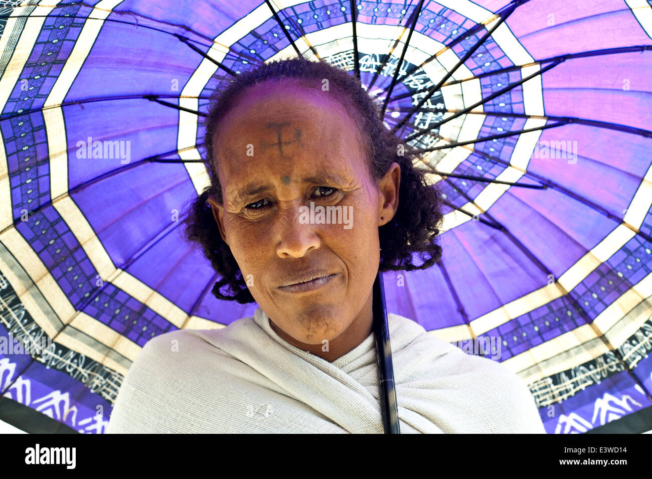 Femme rurale traditionnelle avec hairstyle, croix chrétienne tatoué sur son front et parapluie (Éthiopie) Banque D'Images