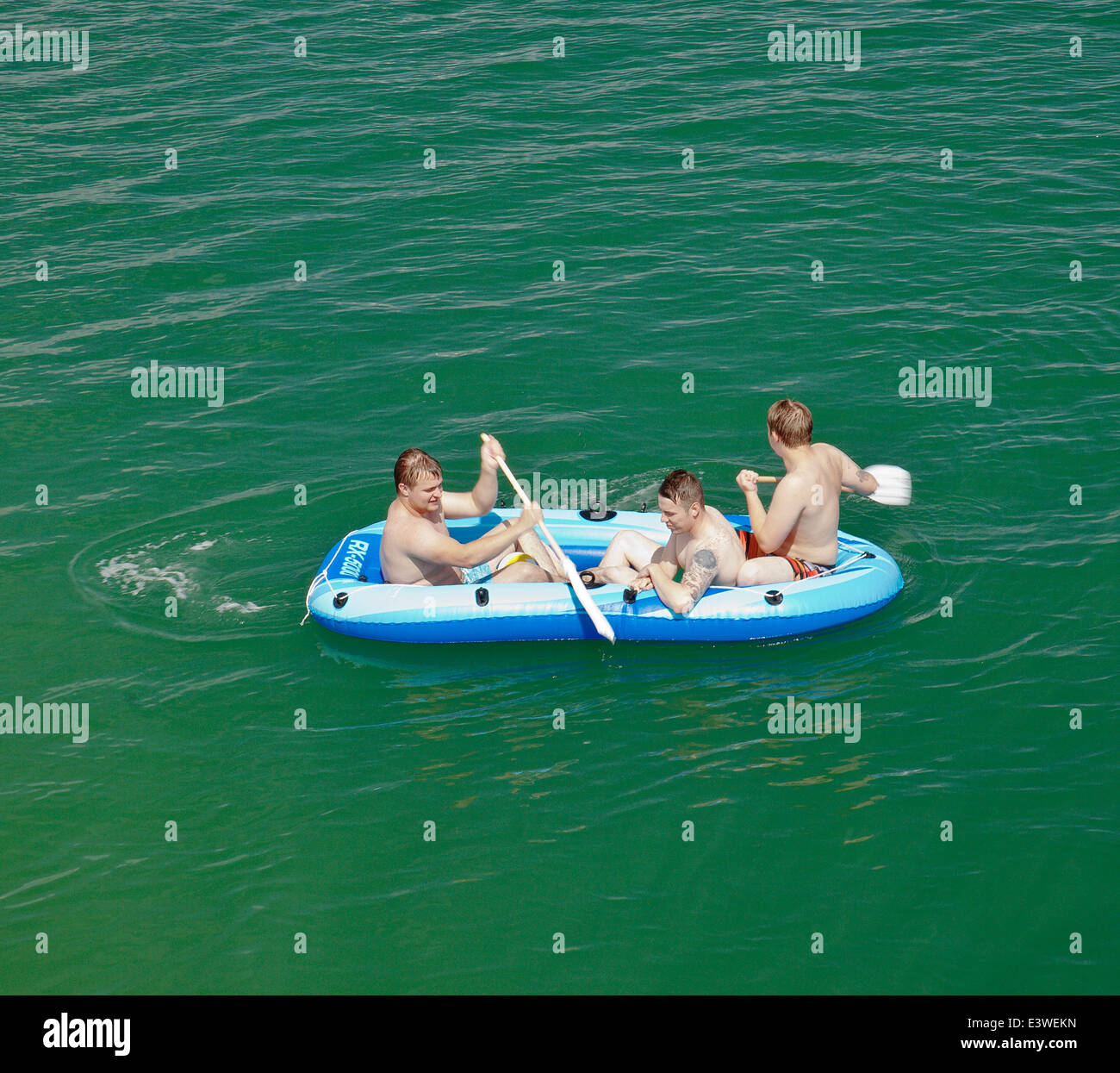Trois hommes dans un bateau gonflable. Banque D'Images