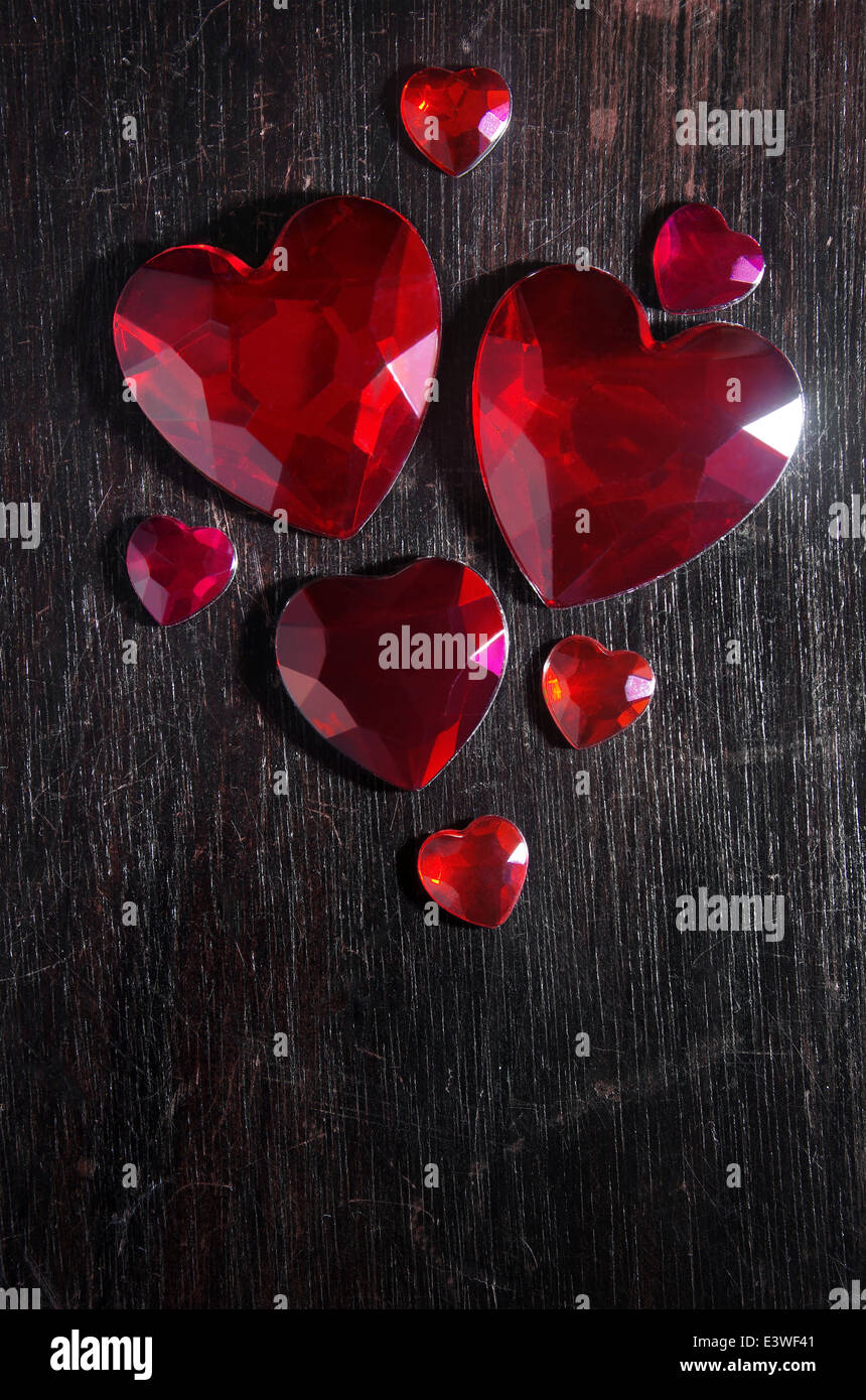 Plusieurs rouge en forme de coeur rubi pierres sur une égratignure sur fond de bois Banque D'Images