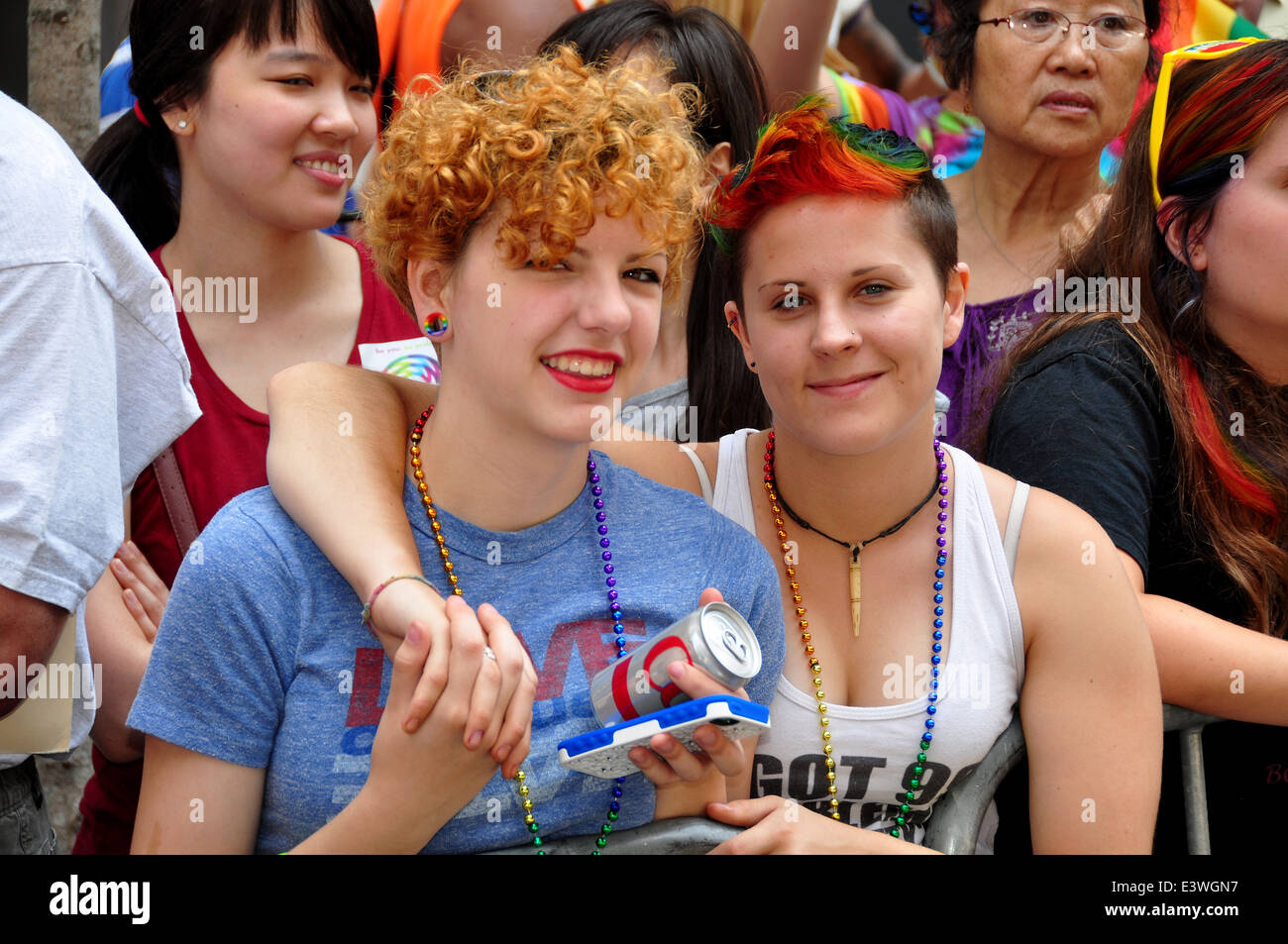 NYC : Deux jeune femme regardant la Gay Pride Parade 2014 sur la Cinquième Avenue Banque D'Images
