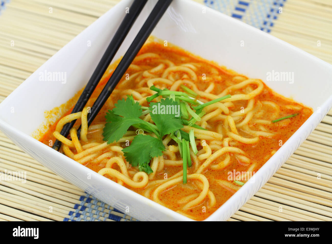 Hot Curry nouilles potage dans un bol sur le tapis de bambou Banque D'Images