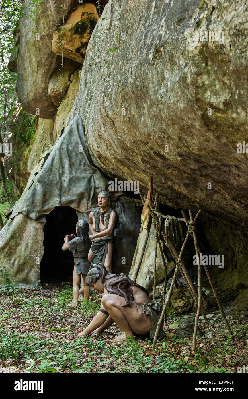Semi-nomades néandertaliens au camp avec abri faites de peaux d'animaux sous surplomb en roche, Préhisto Parc, Tursac, France Banque D'Images