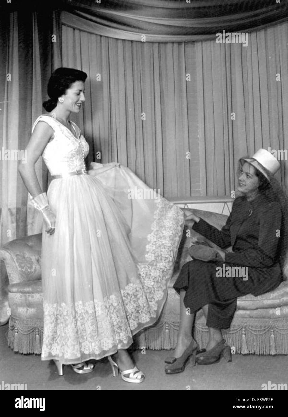 L'image montre un client du Burdines Department Store à Miami choisissant une robe pour un événement de boîte de nuit. Burdines était un établissement de vente au détail populaire connu pour ses offres de mode au milieu du XXe siècle. Banque D'Images