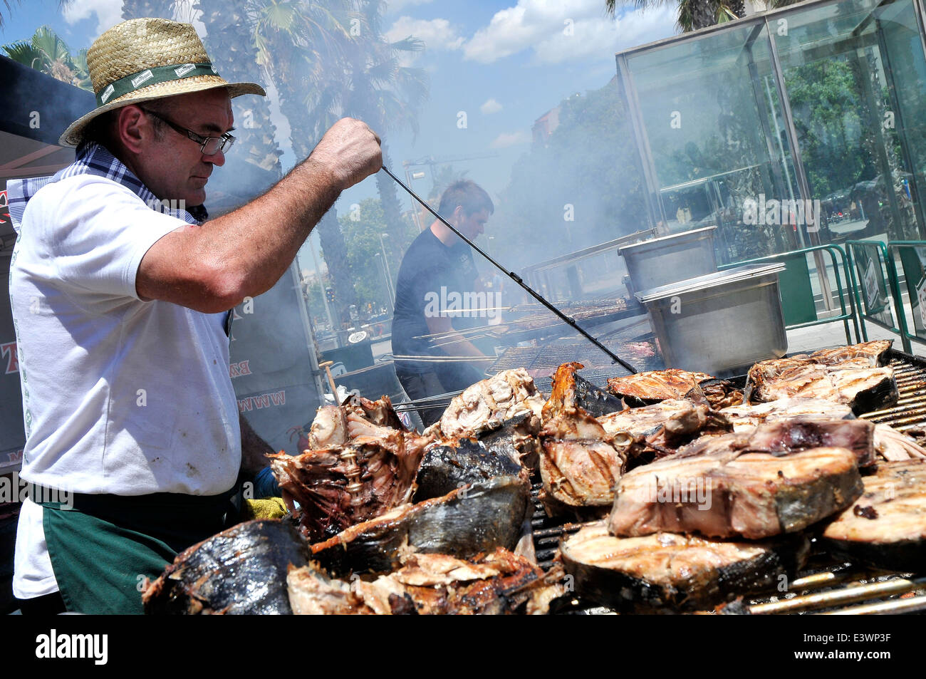 Man grilling poisson grillé dans la rue pour un événement Man grilling poisson grillé dans la rue pour un événement